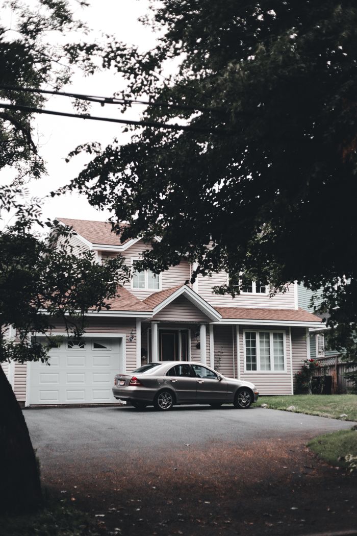 The Art of Drawing Readers In: Your attractive post title goes here A modern suburban house with a parked car on the driveway surrounded by trees.
