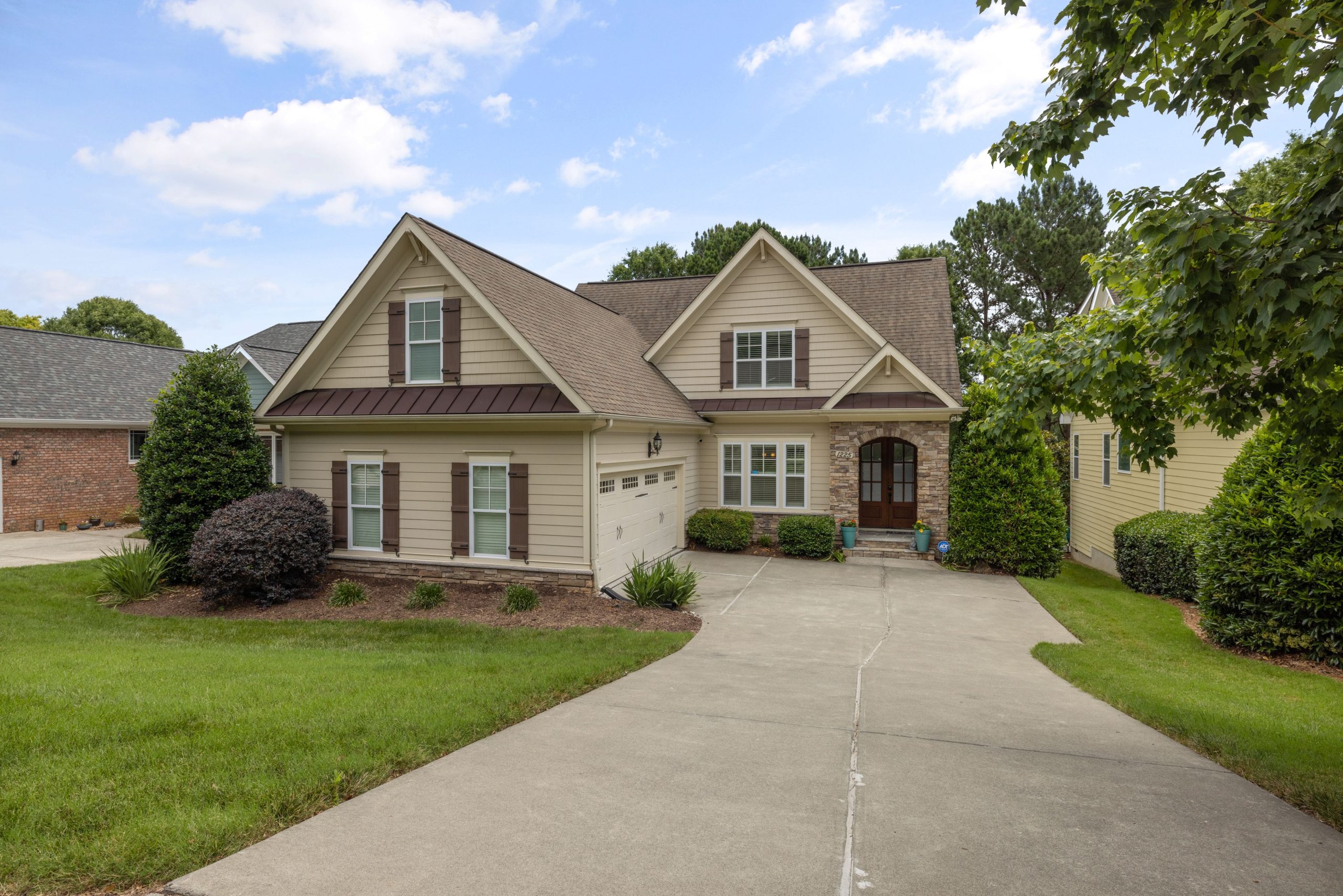 A beautiful suburban family house with a well-maintained lawn and driveway.